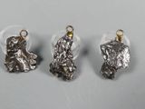 three pieces of silver metal with a small dog on it