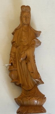 une statue en bois représentant une femme tenant un oiseau