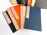 several books are lined up in a row on a white surface
