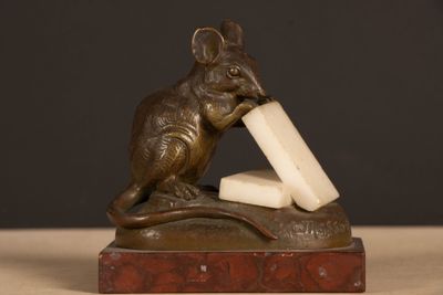 statue of a mouse with a block of cheese in its mouth
