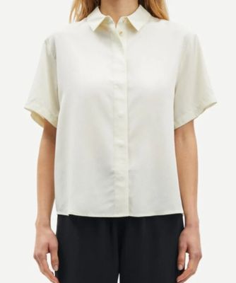 Le mannequin porte une chemise blanche et un pantalon noir.