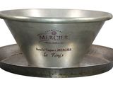 a metal bowl that is sitting on top of a saucer