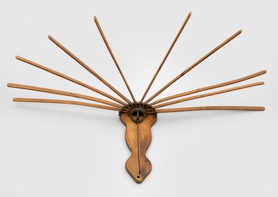 une image représentant une sculpture en bois représentant une tête de cheval d'où sortent des bâtons