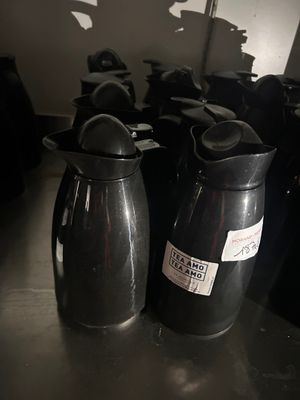 many black vases sitting on a table in a room