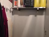 a small bathroom with a toilet and a shelf above the toilet