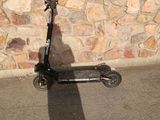 a shadow of a person on a scooter in front of a stone wall