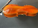 a close up of a violin sitting on a table next to a bow