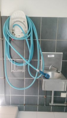 a toilet with a hose attached to it in a bathroom