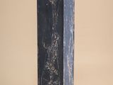 black marble column with a black base on a beige background