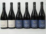 six bouteilles de vin sont alignées sur une table