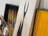a box of utensils sitting on a table next to a knife and fork