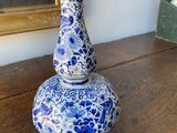 a blue and white vase sitting on top of a wooden table