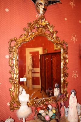 un miroir accroché au mur au-dessus d'une table sur laquelle se trouve un vase