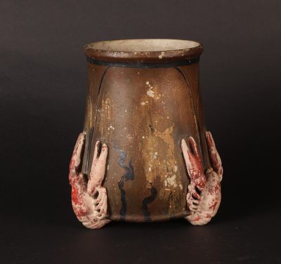 a brown vase with two hands on it