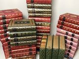 many books stacked on top of each other on a table