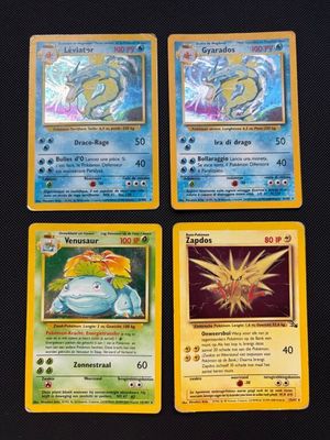 four pokemon cards sitting on top of each other on a table