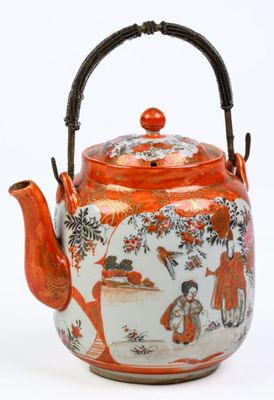 une théière orange et blanche avec une anse et une femme dans un jardin
