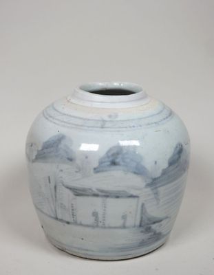 un vase bleu et blanc posé sur une surface blanche