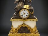 une statue d'un homme assis au sommet d'une horloge