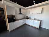 a kitchen with white cabinets and a black refrigerator