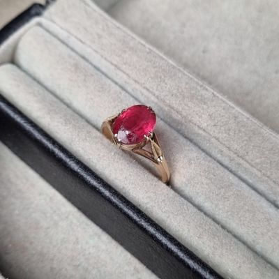 Gros plan sur une bague contenant une pierre rouge