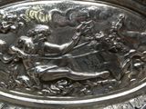 une assiette en argent sur laquelle sont représentés un homme et une femme