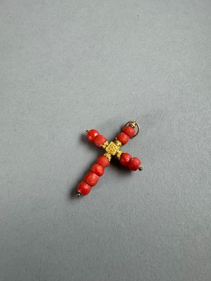 a close up of a cross made out of beads on a table