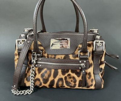 a close up of a purse on a table with a chain