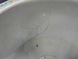 a close up of a bowl on a table with a clock in the background