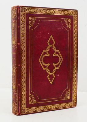 an old red book with a gold design on the cover