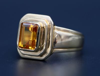 bague en argent sertie d'une citrine sur un fond bleu