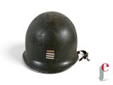 an old helmet is sitting on a white surface next to a keychain