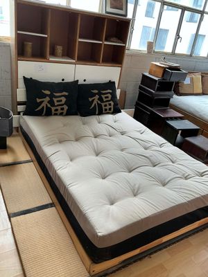 un lit qui se trouve dans une chambre où il y a beaucoup de meubles