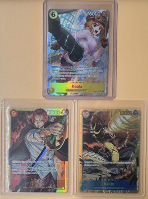 Trois cartes Pokémon différentes sont exposées sur un mur.
