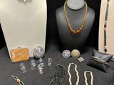 many different necklaces and bracelets on display on a table