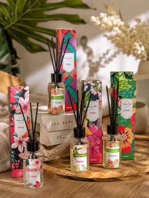 une sélection de roseaux et de bougies posés sur une table ornée de fleurs