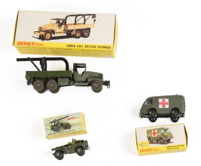 plusieurs véhicules militaires miniatures et une pile de boîtes posés sur une surface blanche