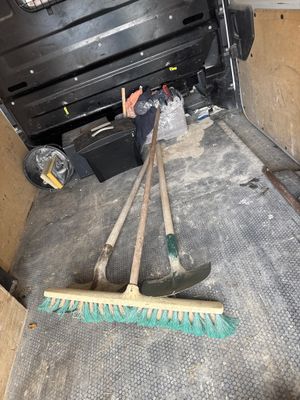 deux balais et un râteau à l'arrière d'un camion