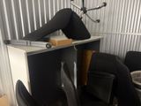 a woman that is sitting on a desk with her legs on the desk