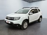 La Dacia blanche est garée dans une grande pièce blanche.