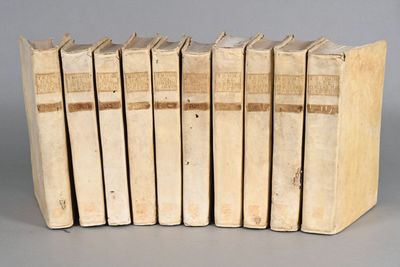 six books are lined up in a row on a gray surface