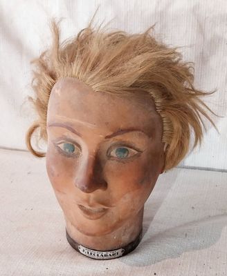 une tête de femme en argile, avec un collier autour du cou