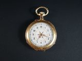 une montre de poche en or posée sur une surface noire