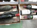 several bottles of wine are in a cardboard box on the floor