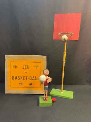 toy figurine of a man holding a basketball ball next to a box of basketball balls