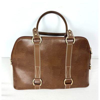 un sac à main en cuir marron à deux anses, orné de ferrures dorées