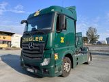 un camion vert garé sur un parking