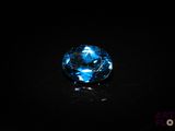 a close up of a blue glass object on a black surface