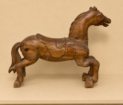 a wooden horse that is standing on a shelf