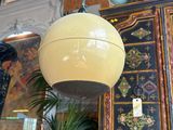 a yellow ball hanging from the ceiling next to a potted plant